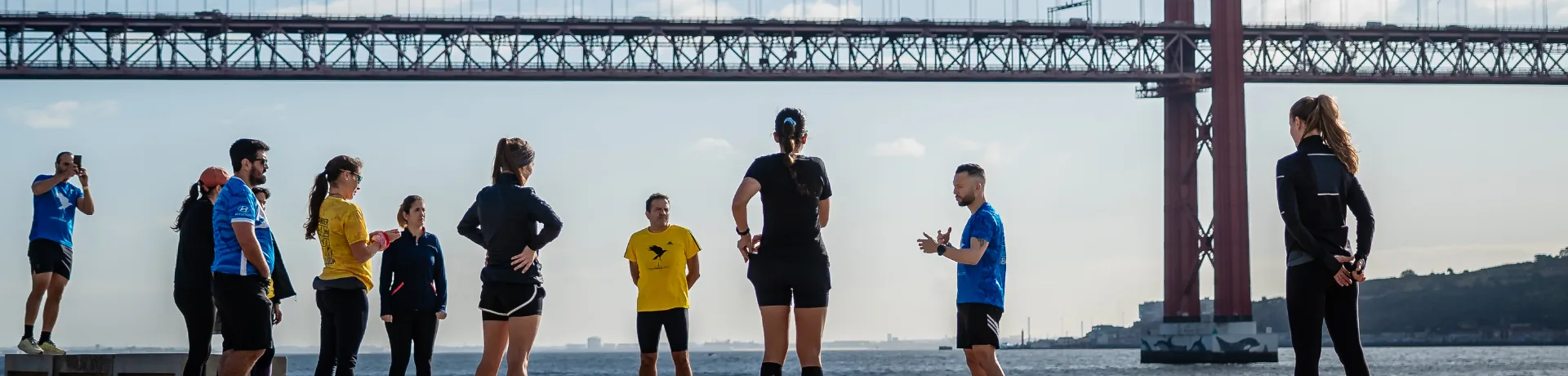 Runners in Lisbon with the 25 de Abril bridge in the background